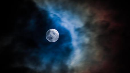 Ethereal Full Moon Amid Scattered Clouds in Night Sky wallpaper