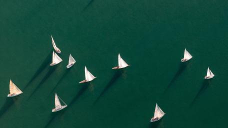 Sailing Ships Gliding Over Serene Waters wallpaper