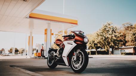 Sleek Motorcycle Fueling Up in Bright Sunshine wallpaper