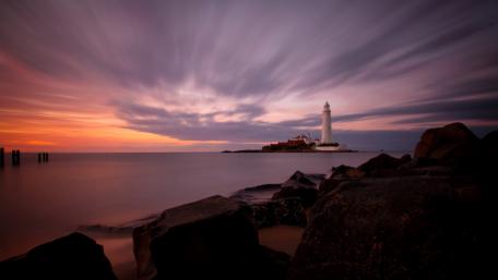 Lighthouse at Dusk Over Tranquil Waters wallpaper