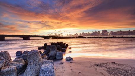 Serene Sunset Over Coastal Breakwater wallpaper