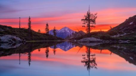 Serene Sunset Reflection Over Mountains wallpaper