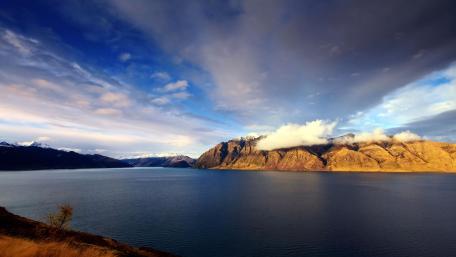Serene Lake Horizon Under Dramatic Clouds wallpaper