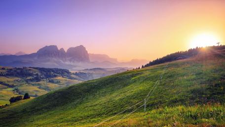 Serene Mountain Sunrise Over Rolling Hills wallpaper