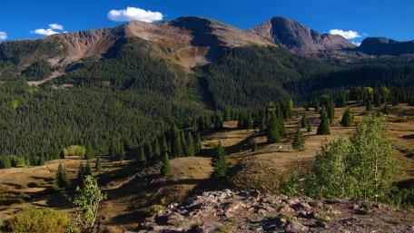 Serene Mountain Landscape with Lush Greenery and Clear Sky wallpaper