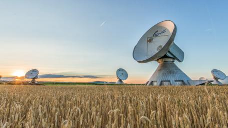 Satellite Dishes in a Serene Wheatfield at Sunset wallpaper