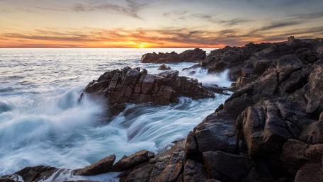 Tranquil Sea Sunset Over Rocky Coastline wallpaper