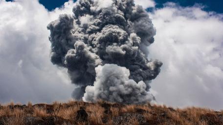 Majestic Smoke Eruption Over Grassland wallpaper