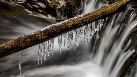 Frozen Beauty Above a Flowing Waterfall wallpaper