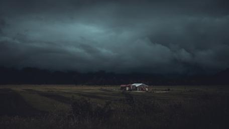 Mysterious Stormy Skies Over Rural Farmhouse wallpaper