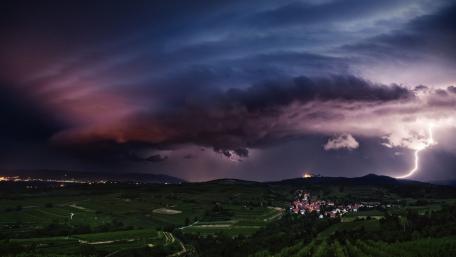Stunning Lightning Over a Serene Village Nightscape wallpaper