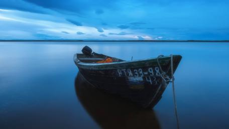Tranquil Boat at Dusk on a Serene Lake wallpaper