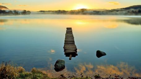 Serene Sunrise Over Tranquil Lake Surface wallpaper