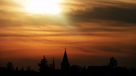 Serene Sunset Over a Charming City Church wallpaper