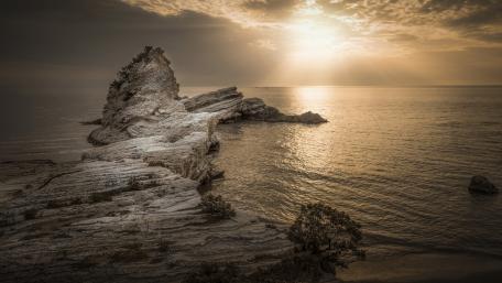 Serene Sunset Over Coastal Rock Formation wallpaper