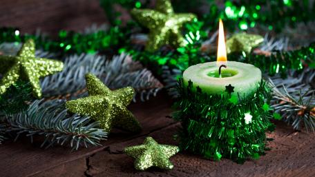 Festive Green Candle for Christmas Celebration wallpaper