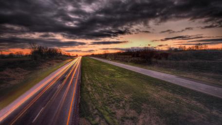 Winding Road Under Dramatic Clouds wallpaper