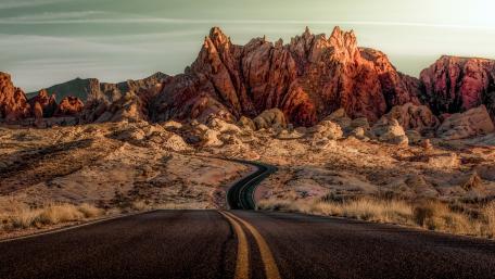Endless Road Through Majestic Desert Mountains wallpaper