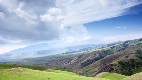 Serene Green Meadows Under Dramatic Skies wallpaper