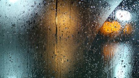 Raindrops on a Window in a Rainy Night Scene wallpaper