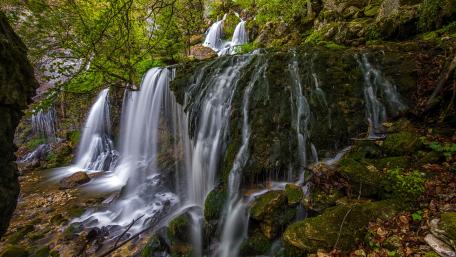 Multiple waterfalls from algae covered rocks wallpaper