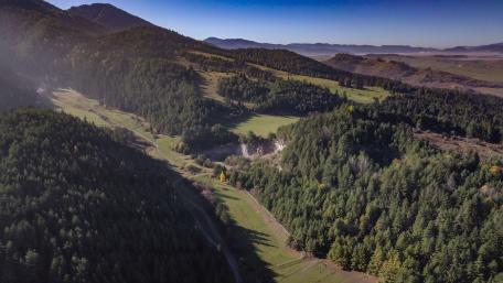 Majestic Valley Surrounded by Lush Greenery and Mountains wallpaper