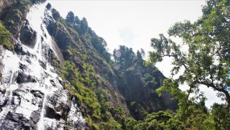 Majestic Waterfall Amidst Lush Mountains wallpaper