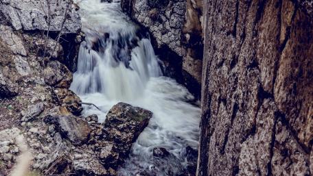Serene Waterfall Amidst Rocky Surroundings wallpaper
