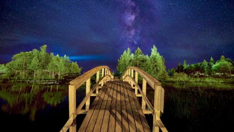 Serene Night Sky Over Tranquil Footbridge wallpaper