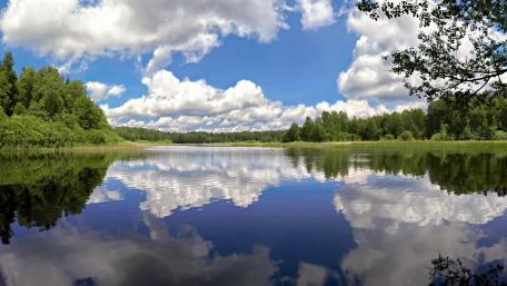 Tranquil Lake Under Fluffy Clouds wallpaper