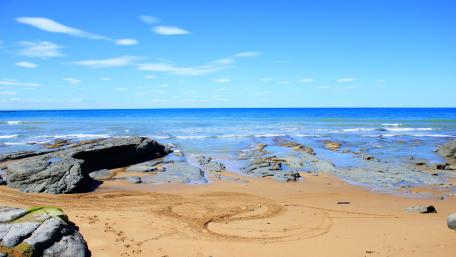 Serene Coastal Beauty Under Blue Skies wallpaper