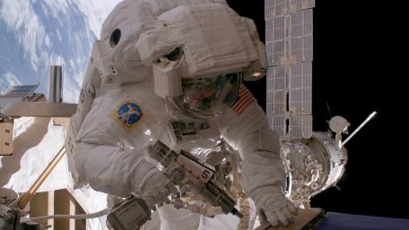 Astronaut in Action Outside the International Space Station wallpaper