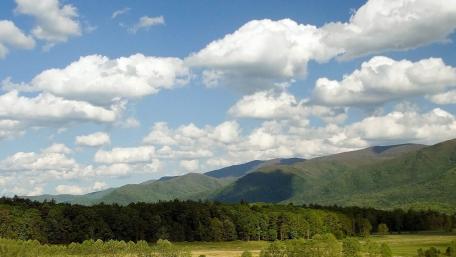 Serene Mountain Landscape with Fluffy Clouds wallpaper