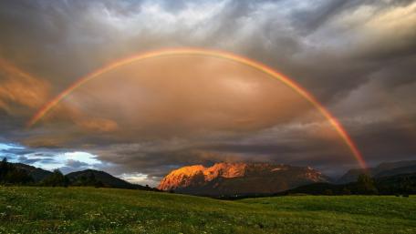 Rainbow Over Serene Field and Mountains wallpaper