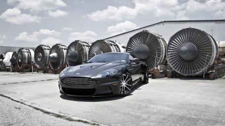 Sleek Aston Martin Among Industrial Turbines wallpaper