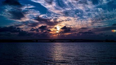 Serene Dark Sunset Over Water and Bridge wallpaper