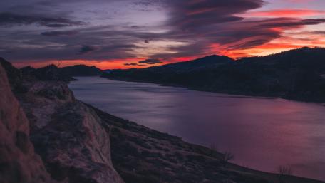 Serene Pink Sunset Over a Tranquil River wallpaper