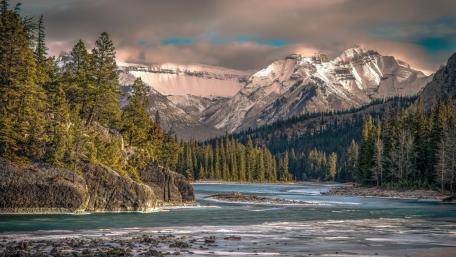 Majestic River Beneath Snow-Capped Mountains wallpaper