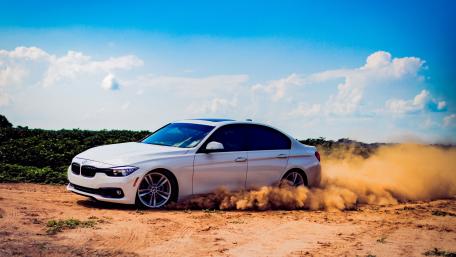 Sleek BMW Drifting on Dusty Terrain wallpaper