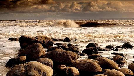 Serene Coastal Waves Among Boulder Formations wallpaper