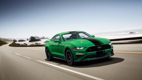 Green Ford Mustang Speeding on Coastal Road wallpaper