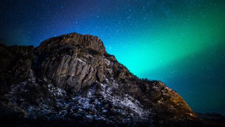 Radiant Northern Lights Over Majestic Mountain Peaks wallpaper