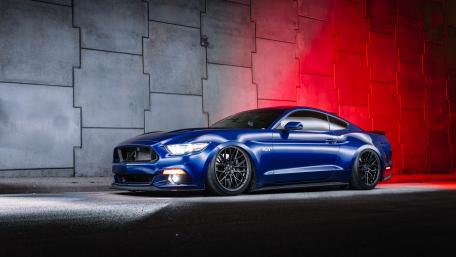 Sleek Blue Ford Mustang Under Neon Lights wallpaper