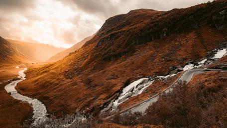 Majestic Mountain Pass with River View in Autumn Light wallpaper