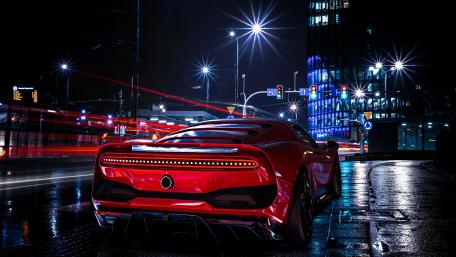 Sleek Red Sports Car in a Night Cityscape wallpaper
