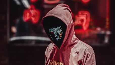 Mysterious Hooded Figure in Neon Mask wallpaper