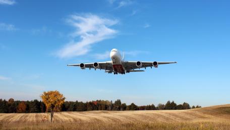 Majestic Airbus A380 in Flight Over Scenic Landscape wallpaper