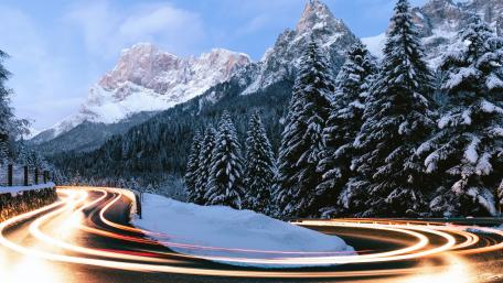 Winding Winter Road Through Snowy Mountains wallpaper