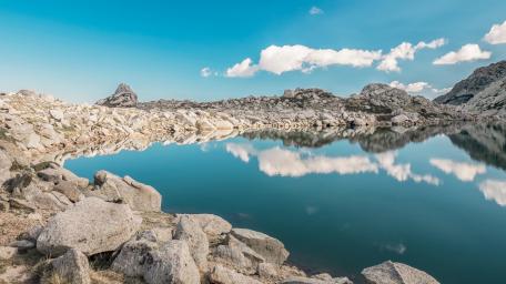 Tranquil Lake Under a Blue Sky with Reflections wallpaper