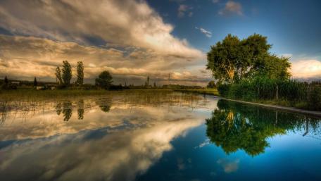 Serene Lake Reflection Under Dramatic Clouds wallpaper